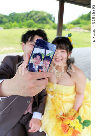 イエローのカクテルドレスの新婦様とブラウンのタキシードの新郎様のフォトウエディング・ウエディングドレ 91926898