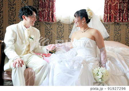 ウエディングドレス姿の新婦様と白タキシードの新郎様フォトウエディングスタジオ撮影、ブライダルフォト前 91927296
