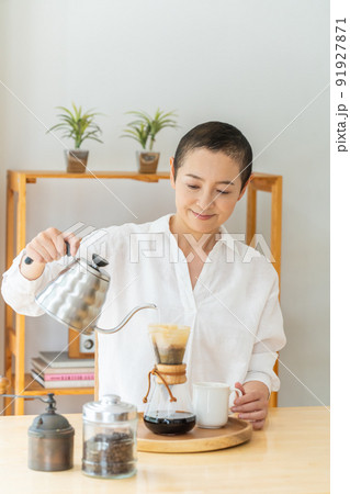 リビングでコーヒを入れるミドル女性 リビングでコーヒを入れるミドル女性 91927871