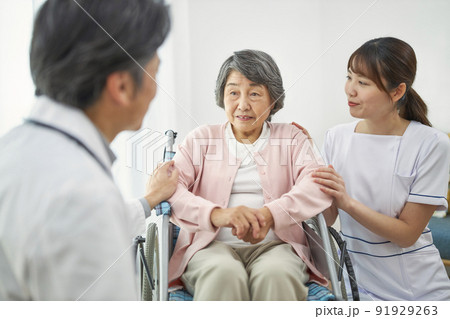 車椅子に座るシニアの女性と医療従事者 91929263