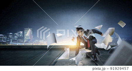 Determined businessman leaving fire trails on asphalt 91929457