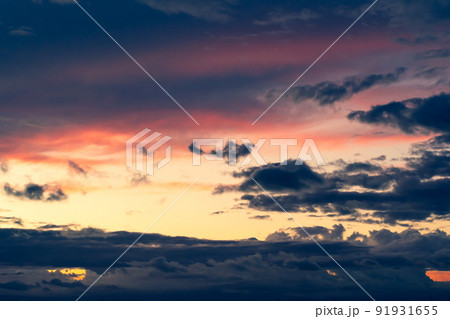 夕焼け空を覆い隠す灰色の雨雲　a-3 暖色寒色強調 91931655