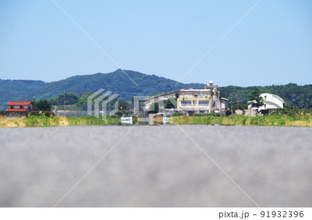 夏の炎天下のアスファルト路面の遠くで風景が陽炎に揺らいでいる光景 夏の炎天下のアスファルト路面の遠くで風景が陽炎に揺らいでいる光景 91932396