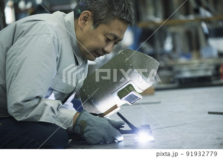 溶接工イメージ　空調作業服を着て溶接をするミドル男性作業員 91932779