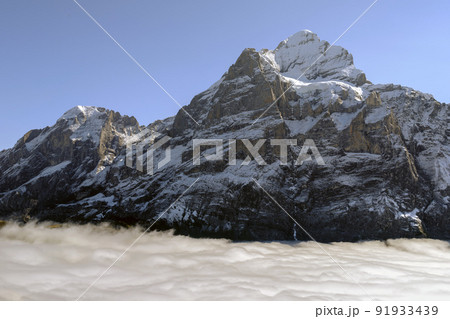 Mountains and clouds in the valley. Natural landscape high in the mountains. Grindewald, Switzerland. Mountains and clouds in the valley. Natural landscape high in the mountains. Grindewald, Switzerland. 91933439