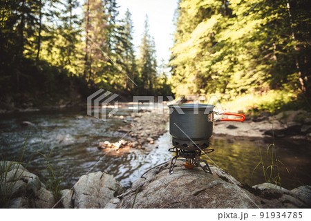 Cooking food using camping gas during the hike. Cooking food using camping gas during the hike. 91934785