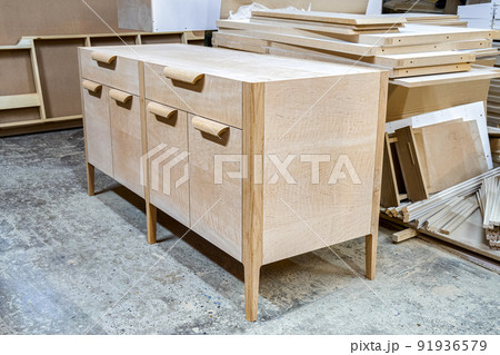 Chest of drawers made of solid alder in process of production at workshop. Creation of modern domestic furniture for bedroom interior Chest of drawers made of solid alder in process of production at workshop. Creation of modern domestic furniture for bedroom interior 91936579
