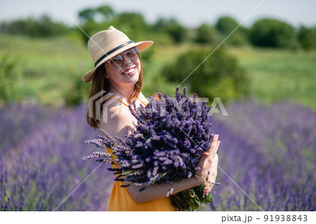 Girl in a yellow dress and a straw hat with a huge bouquet of lavender flowers. Girl in a yellow dress and a straw hat with a huge bouquet of lavender flowers. 91938843
