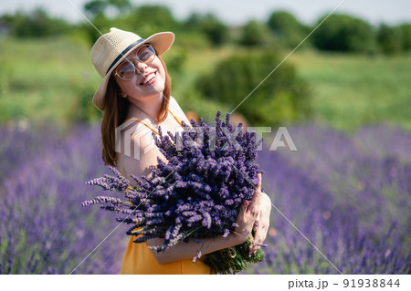 Girl in a yellow dress and a straw hat with a huge bouquet of lavender flowers. Girl in a yellow dress and a straw hat with a huge bouquet of lavender flowers. 91938844