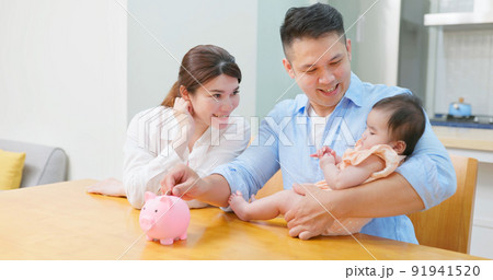 parents put coin in piggybank parents put coin in piggybank 91941520