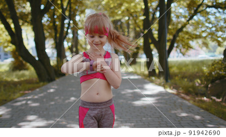Athletic runner girl look at smart watch clock device fitness bracelet checking time, heart rate Athletic runner girl look at smart watch clock device fitness bracelet checking time, heart rate 91942690