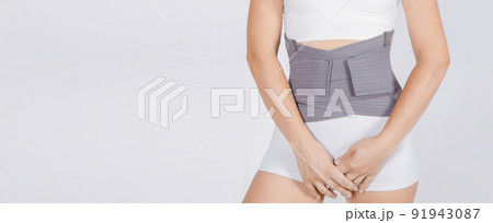 Lumbar brace on the human body isolated on a white background. Trauma of back. Back brace, orthopedic lumbar, support belt for back muscles. Lower back problems health. 91943087