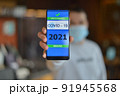 Covid-19 Health Passport. Vaccinated man holding cell phone with covid 19 vaccination proof 91945568