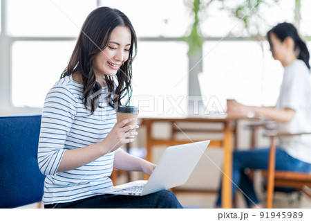 カフェでノートPCを操作する若い女性 91945989