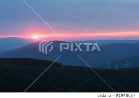 Wind turbines in Bear mountain , view from upper water reservoir of the pumped storage hydro power plant Dlouhe Strane in Jeseniky Mountains, Czech Republic. Summer sunset. Wind turbines in Bear mountain , view from upper water reservoir of the pumped storage hydro power plant Dlouhe Strane in Jeseniky Mountains, Czech Republic. Summer sunset. 91948037