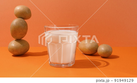 A glass of potato milk on the table with potatoes A glass of potato milk on the table with potatoes 91949129