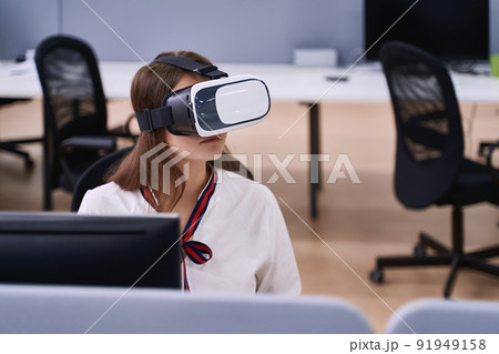 Female professional using vr virtual reality headset at desk in office 91949158