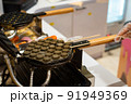 Hong Kong charcoal Waffle is baked on waffle iron machine. 91949369