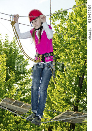 a teenage girl goes on hinged trail in extreme rope park 91949506