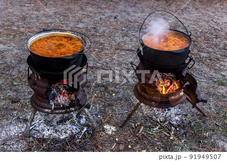 two cauldrons with red borsch on fire 91949507