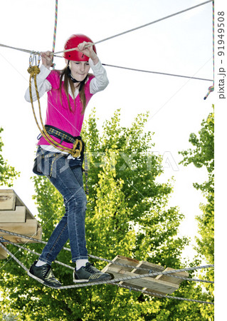 a teenage girl goes on hinged trail in extreme rope park 91949508