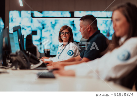 Group of Security data center operators working in a CCTV monitoring room looking on multiple monitors Officers Monitoring Multiple Screens for Suspicious Activities Team working on the System Contr Group of Security data center operators working in a CCTV monitoring room looking on multiple monitors Officers Monitoring Multiple Screens for Suspicious Activities Team working on the System Contr 91950874