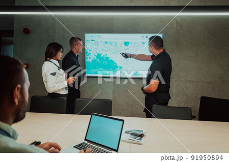 Group of Security data center operators working in a CCTV monitoring room looking on multiple monitors Officers Monitoring Multiple Screens for Suspicious Activities Team working on the System Contr 91950894