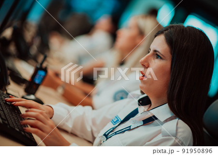 Female security operator working in a data system control room offices Technical Operator Working at workstation with multiple displays, security guard working on multiple monitors 91950896