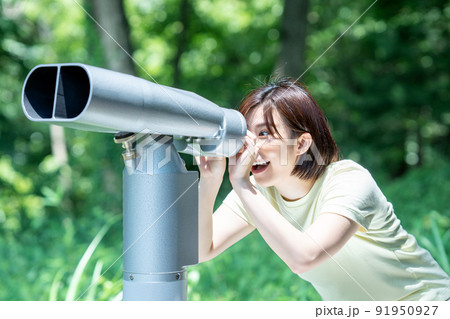 コイン式望遠鏡で景色を楽しむ女性 91950927