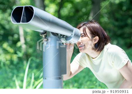 コイン式望遠鏡で景色を楽しむ女性 91950931