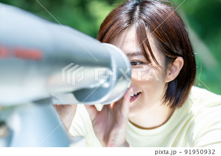 コイン式望遠鏡で景色を楽しむ女性 91950932