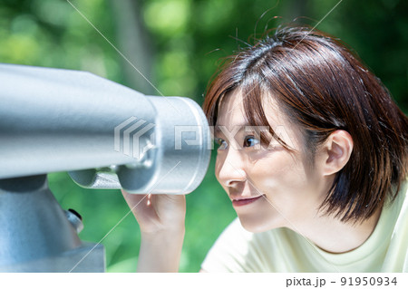 コイン式望遠鏡で景色を楽しむ女性 91950934