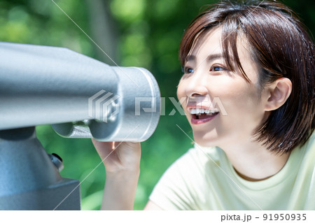 コイン式望遠鏡で景色を楽しむ女性 91950935