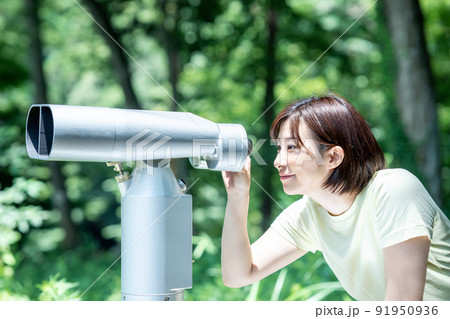コイン式望遠鏡で景色を楽しむ女性 91950936