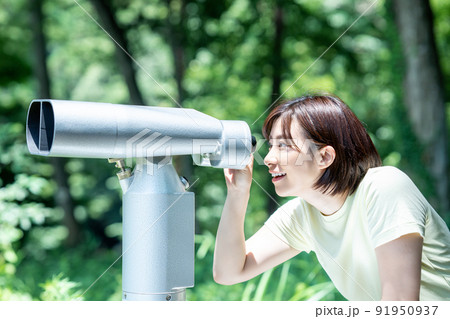 コイン式望遠鏡で景色を楽しむ女性 91950937
