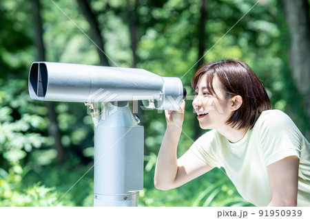 コイン式望遠鏡で景色を楽しむ女性 91950939