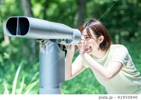 コイン式望遠鏡で景色を楽しむ女性 91950940