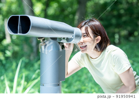 コイン式望遠鏡で景色を楽しむ女性 91950941