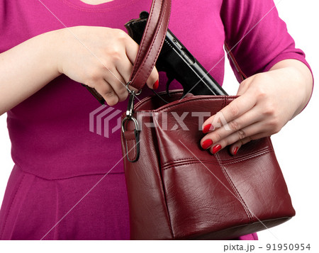 The woman pulls out a gun from her purse. 91950954