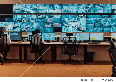Empty interior of big modern security system control room, workstation with multiple displays, monitoring room with at security data center Empty office, desk, and chairs at a main CCTV security data 91950985