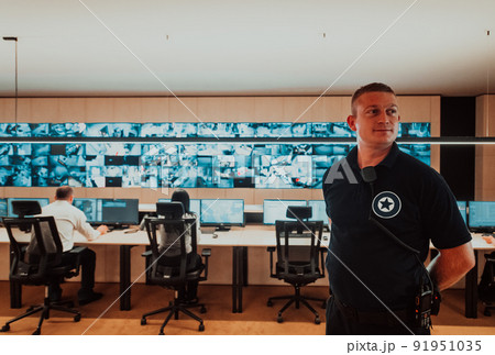 Male security operator working in a data system control room offices Technical Operator Working at workstation with multiple displays, security guard working on multiple monitors Male computer opera 91951035