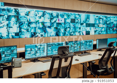 Empty interior of big modern security system control room, workstation with multiple displays, monitoring room with at security data center Empty office, desk, and chairs at a main CCTV security data 91951053