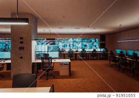 Empty interior of big modern security system control room, workstation with multiple displays, monitoring room with at security data center Empty office, desk, and chairs at a main CCTV security data 91951055