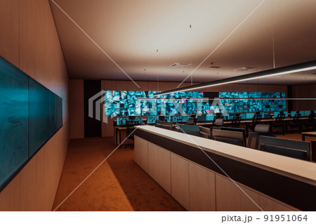 Empty interior of big modern security system control room, workstation with multiple displays, monitoring room with at security data center Empty office, desk, and chairs at a main CCTV security data 91951064
