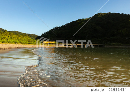 朝焼けの宮崎県日南市山王浜の波打ち際の隈谷川橋梁を走る日南線キハ40 91951454