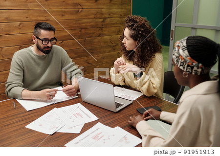 Group of young interracial coworkers brainstorming during discussion Group of young interracial coworkers brainstorming during discussion 91951913