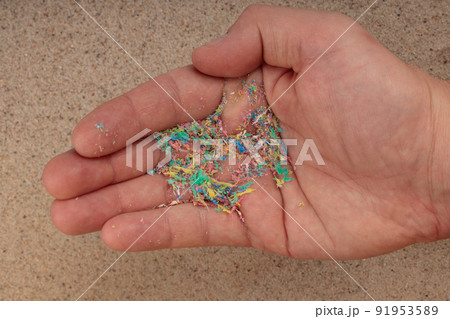 Micro plastic on the palm of your hand, top view of the beach. An environmental problem. Micro plastic on the palm of your hand, top view of the beach. An environmental problem. 91953589