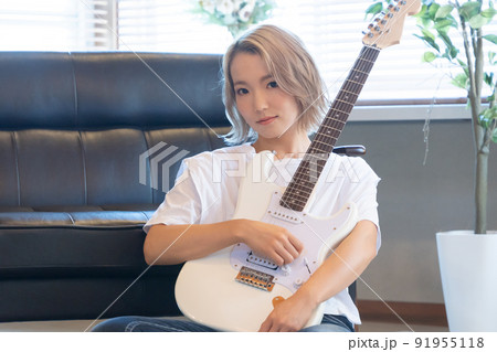 白いエレキギターと若い女性 91955118