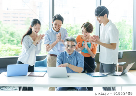 パソコンを見ながら拍手をするビジネスパーソン パソコンを見ながら拍手をするビジネスパーソン 91955409