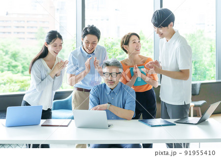 パソコンを見ながら拍手をするビジネスパーソン パソコンを見ながら拍手をするビジネスパーソン 91955410